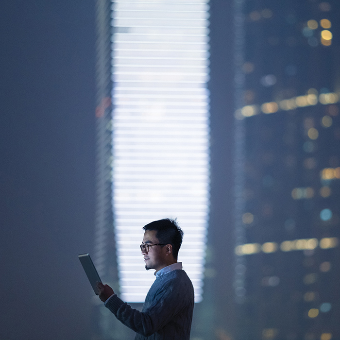 Man on iPad in front of beam of light
