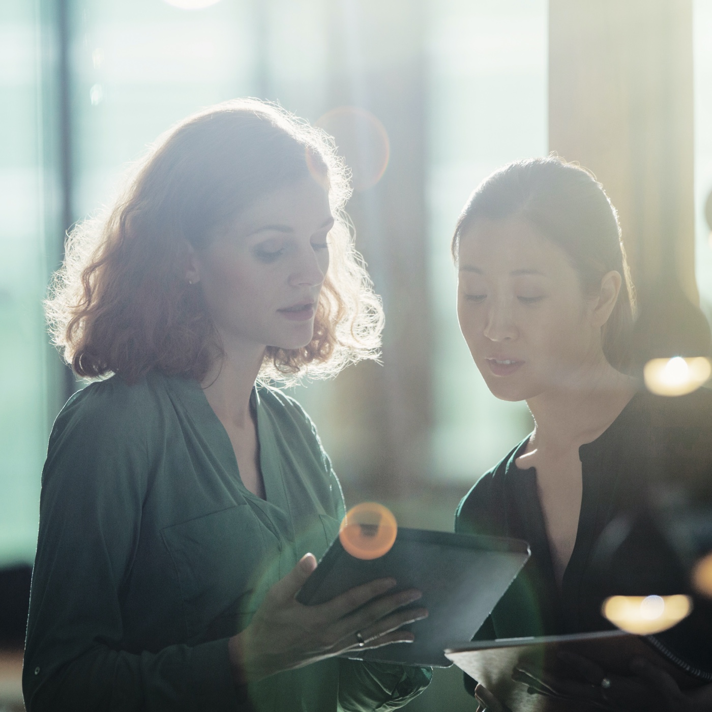 Two women talking looking at an iPad