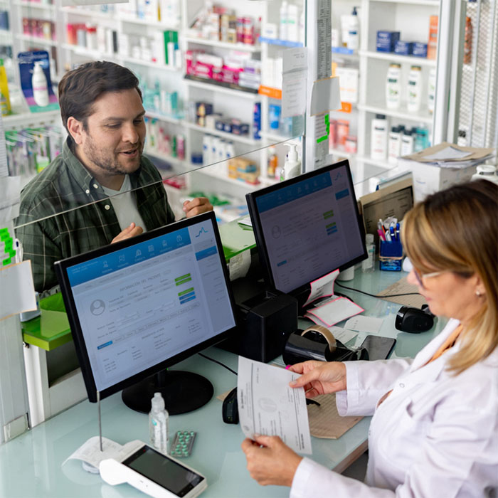 A customer buying medication at the pharmacy counter