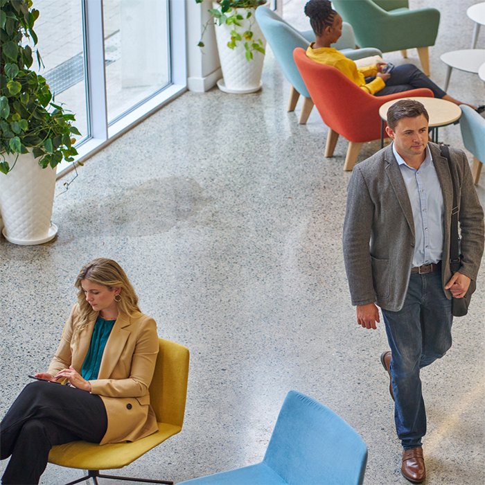 In the lobby, two people seated, one walking through