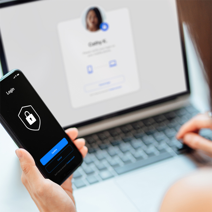 woman looking at her mobile and laptop